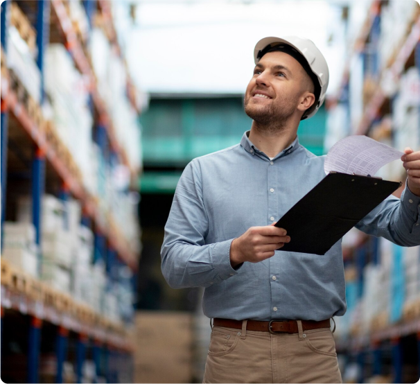 Un hombre en un almacén sosteniendo un portapapeles, inspeccionando el inventario y garantizando la documentación adecuada.